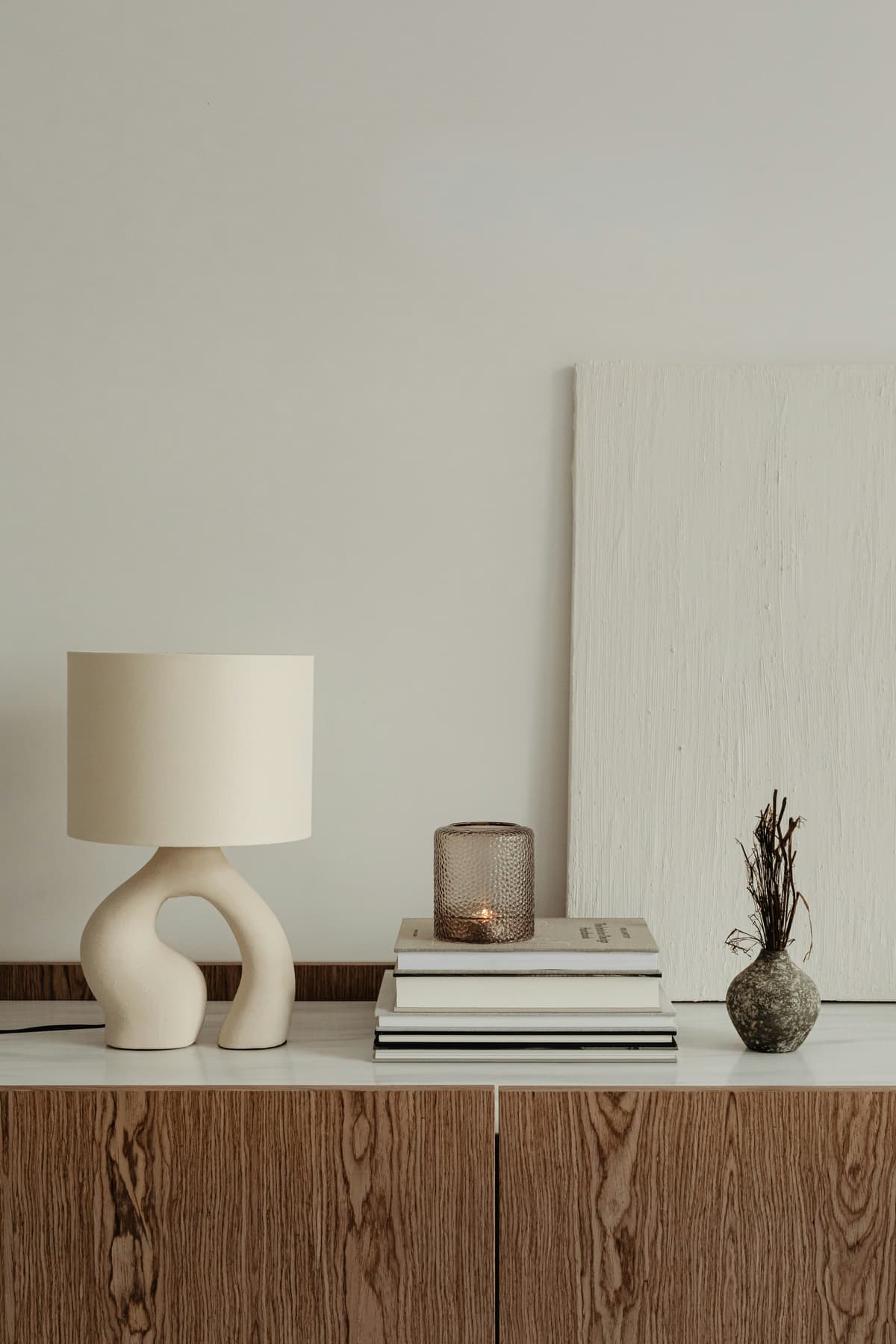 Close-up of a smooth off-white painted wall with a sculptural table lamp